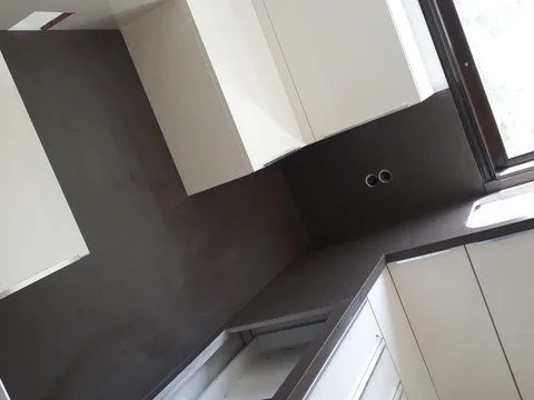 Koyu renkli tezgah, köşe düzeni ve pencere kenarı