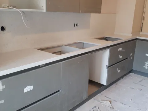 Açık renkli tezgah ve gri dolaplar (montaj aşaması)